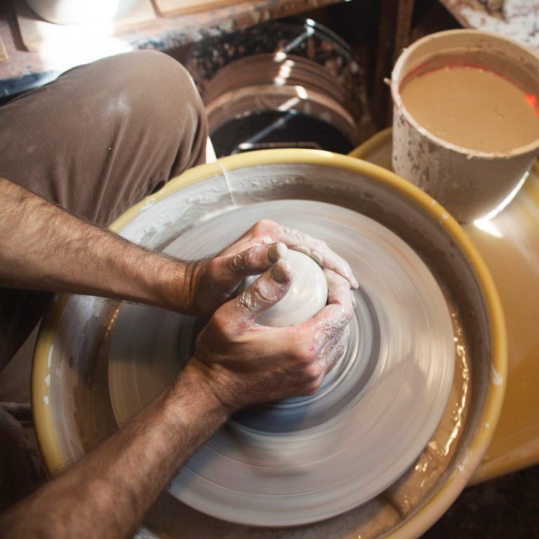 Artisan réalisant à la main une assiette en grès Réalisation d'une assiette en grès tournée à la main